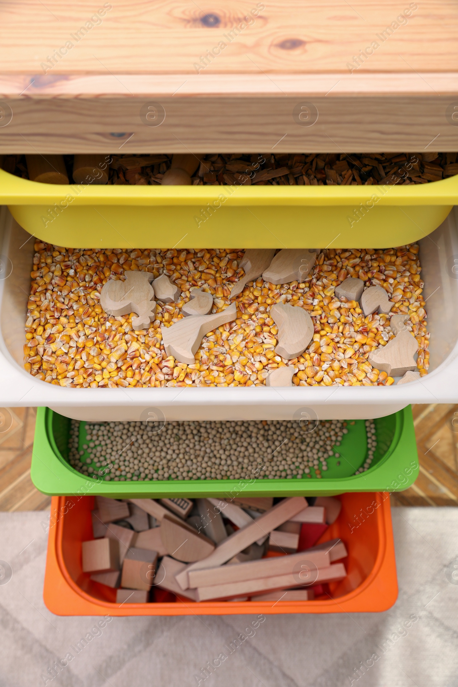 Photo of Shelving unit with different sensory games indoors, above view. Montessori toy