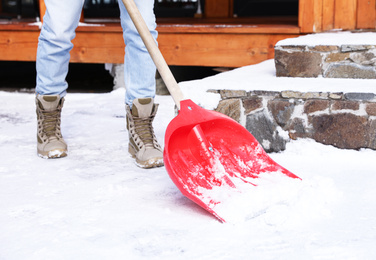 Man removing snow with shovel on winter day, closeup