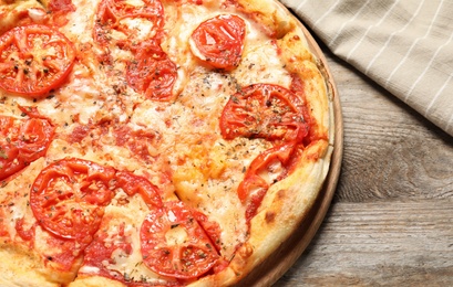 Hot cheese pizza Margherita on wooden table, closeup. Space for text