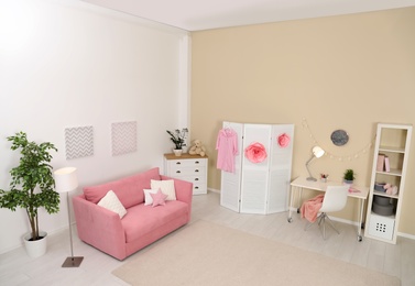 Photo of Cozy child room interior with sofa, study station and modern decor elements