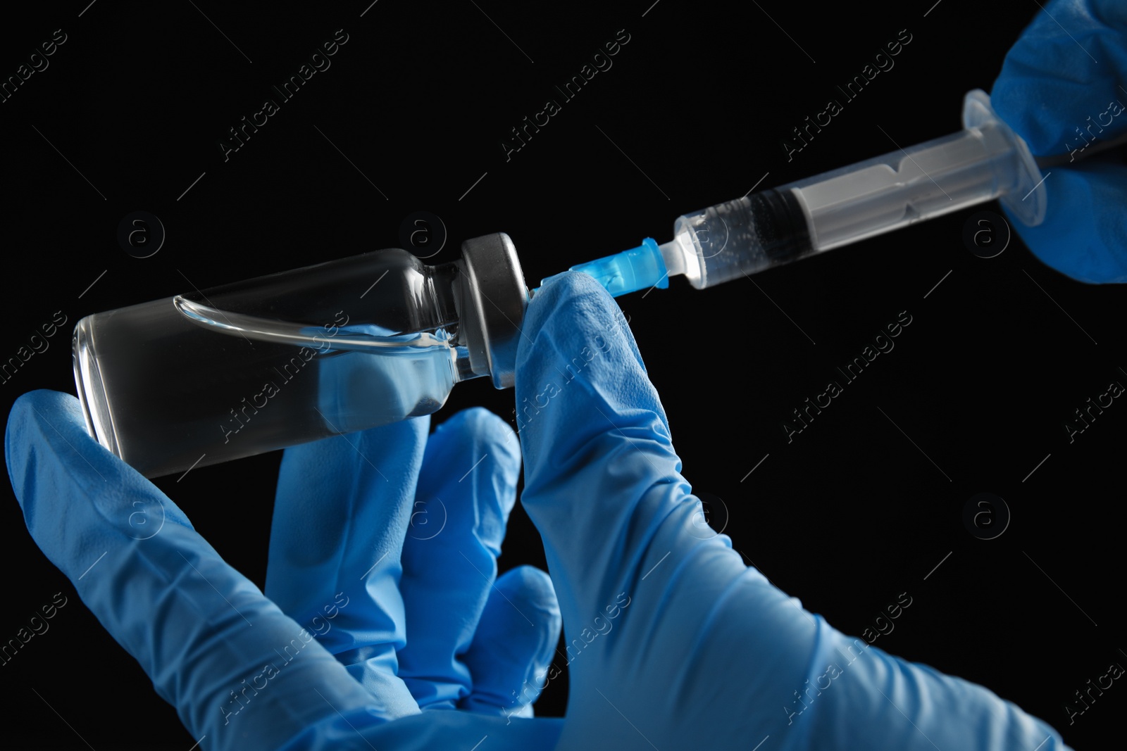 Photo of Doctor filling syringe with medication on black background, closeup. Vaccination and immunization