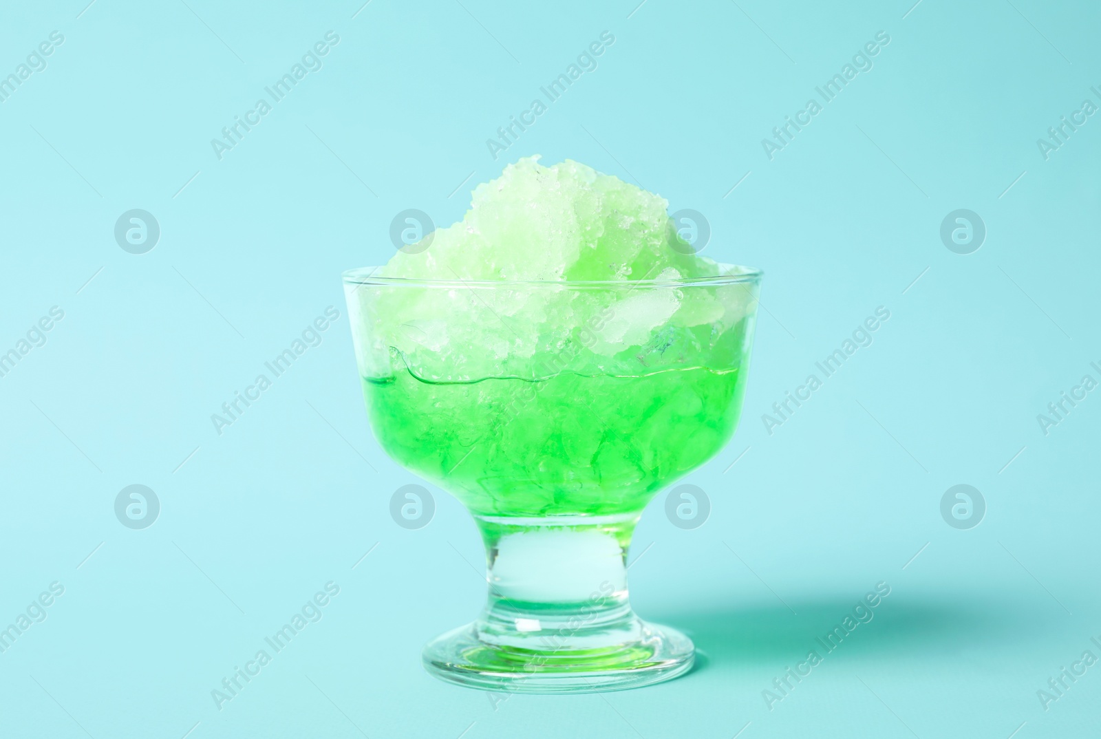 Photo of Shaving ice in glass dessert bowl on light blue background