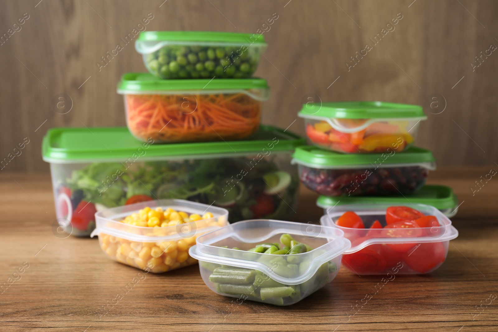 Photo of Set of plastic containers with fresh food on wooden  table