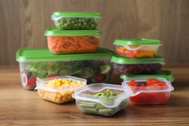 Set of plastic containers with fresh food on wooden  table