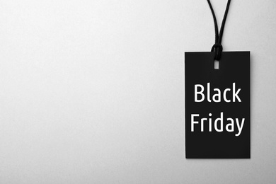 Tag with phrase BLACK FRIDAY on white background, top view. Space for text