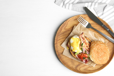 Photo of Delicious egg Benedict served on white wooden table, flat lay. Space for text