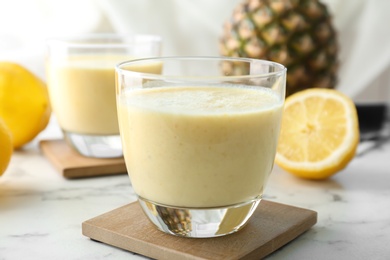 Glass with healthy detox smoothie and ingredients on table