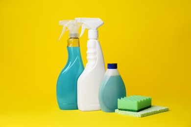 Photo of Cleaning supplies and tools on yellow background