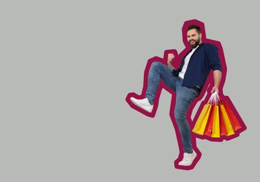 Happy man with shopping bags on grey background, space for text