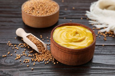 Photo of Delicious mustard and seeds on dark wooden table, closeup