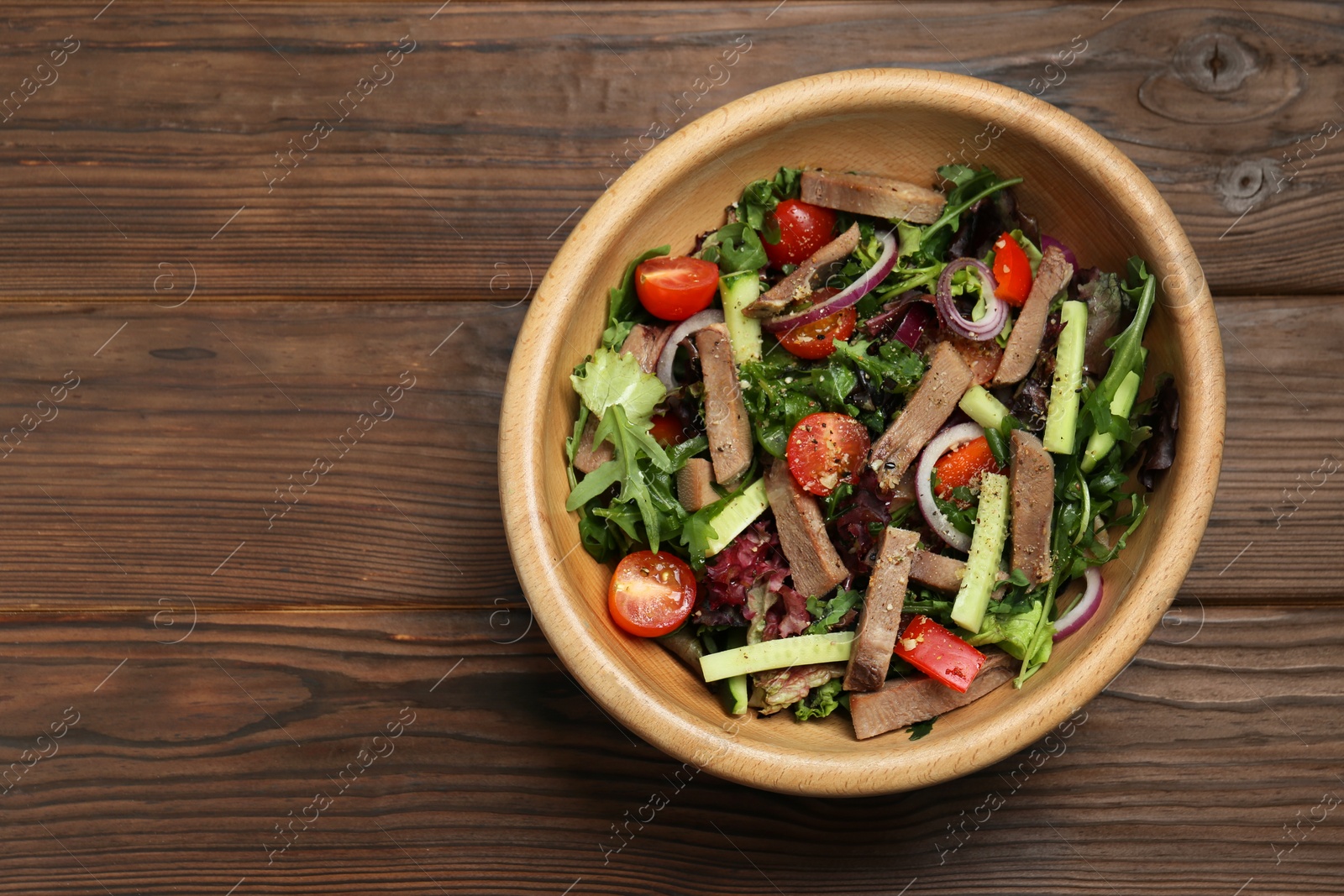 Photo of Delicious salad with beef tongue and vegetables on wooden table, top view. Space for text