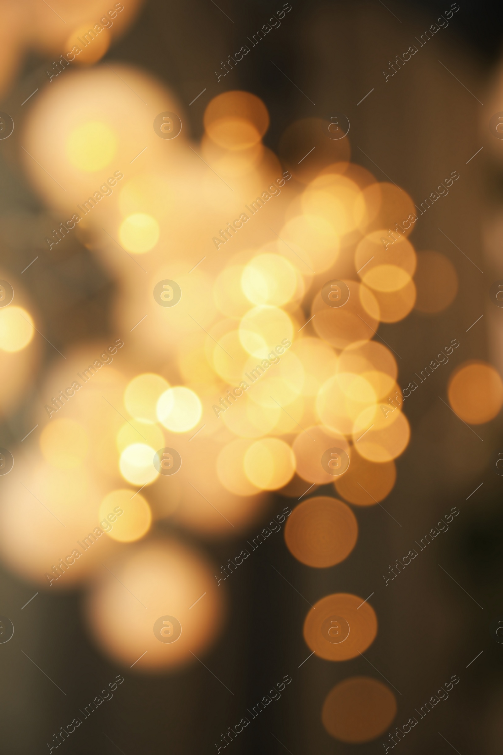 Photo of Blurred view of gold lights on dark background. Bokeh effect