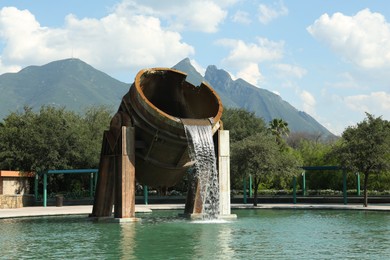 Monterrey, Mexico - September 11, 2022: Fuente de Crisol (Melting Pot Fountain) and beautiful mountains in Parque Fundidora