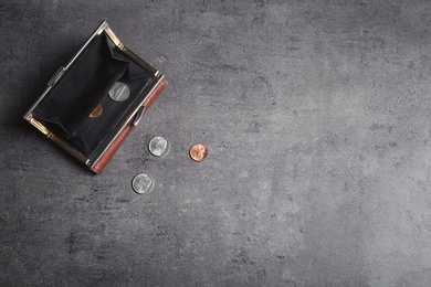 Photo of Wallet with coins and space for text on grey background, top view. Poverty concept
