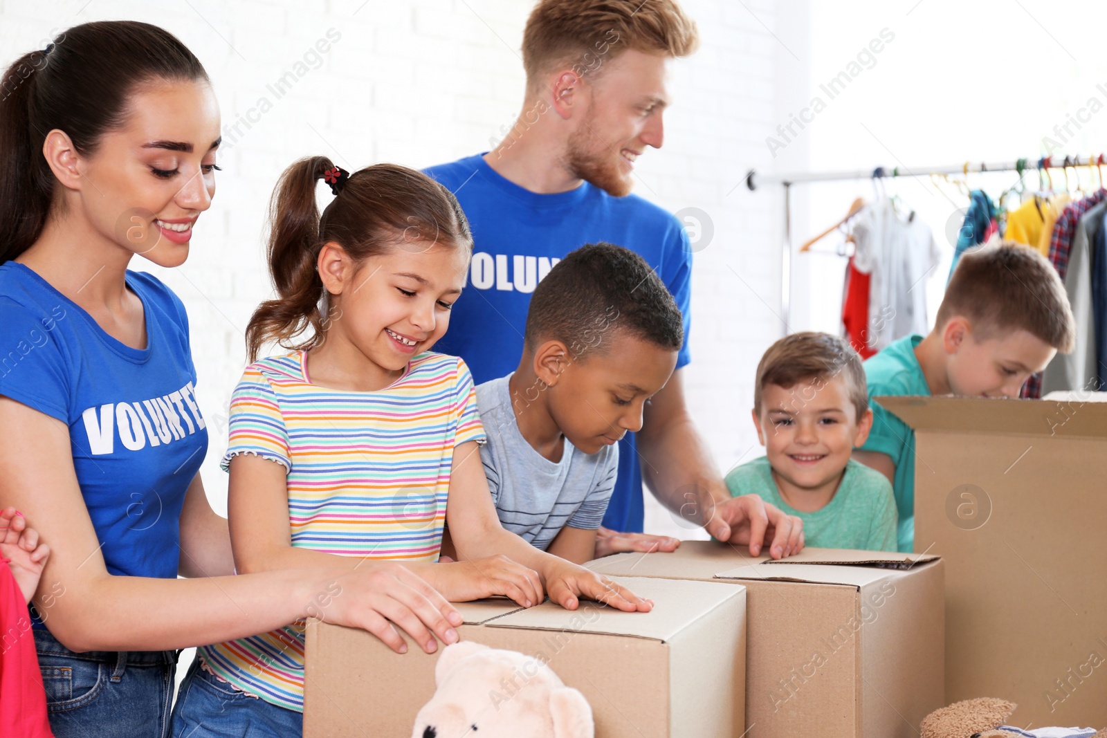 Photo of Volunteers with children sorting donation goods indoors