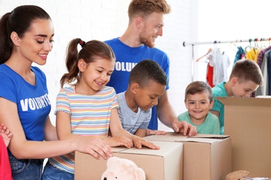 Photo of Volunteers with children sorting donation goods indoors