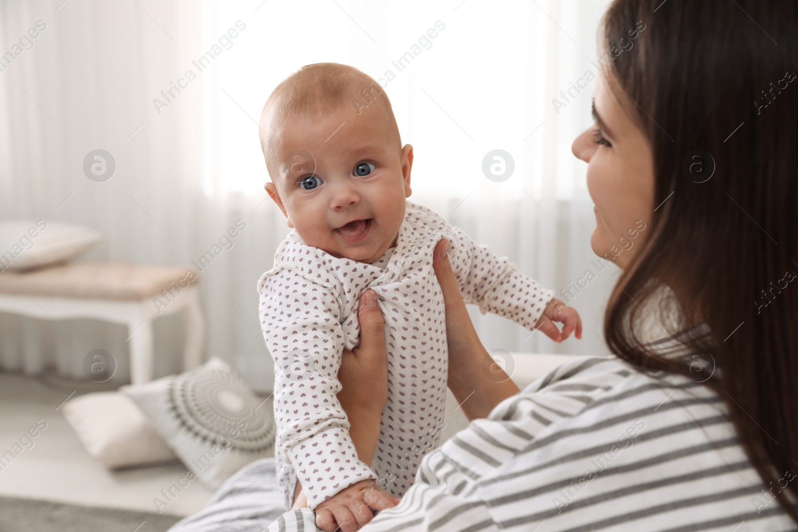 Photo of Young woman with her cute baby at home