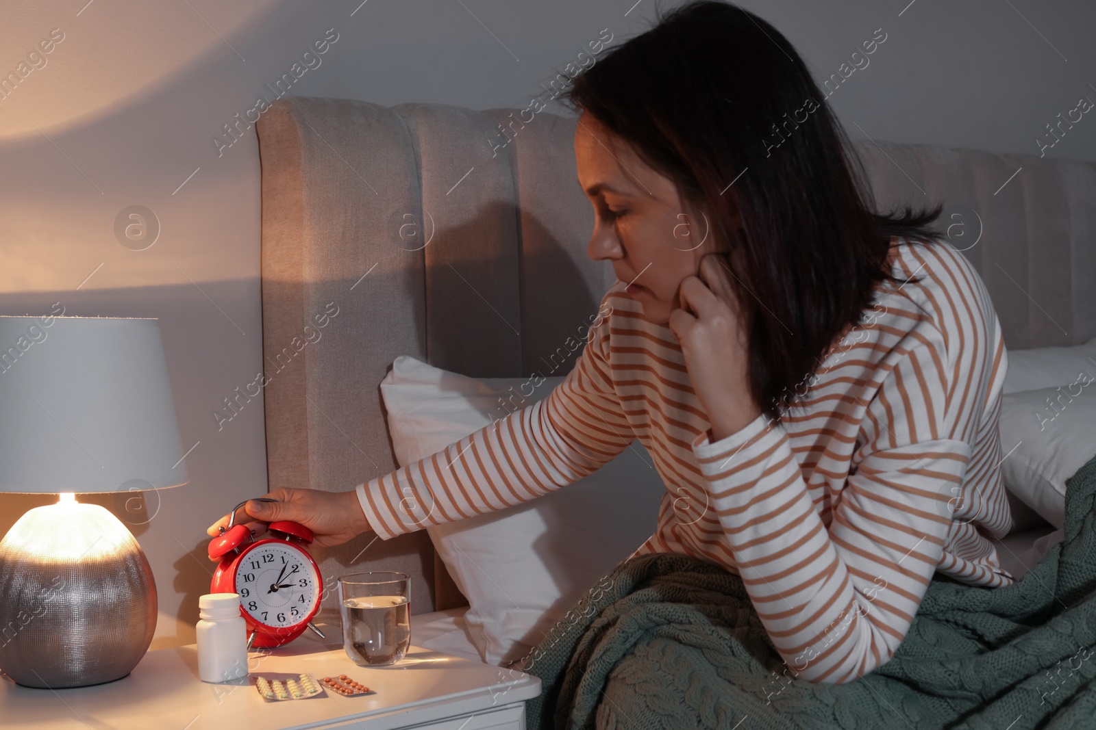 Photo of Mature woman suffering from insomnia in bedroom at night