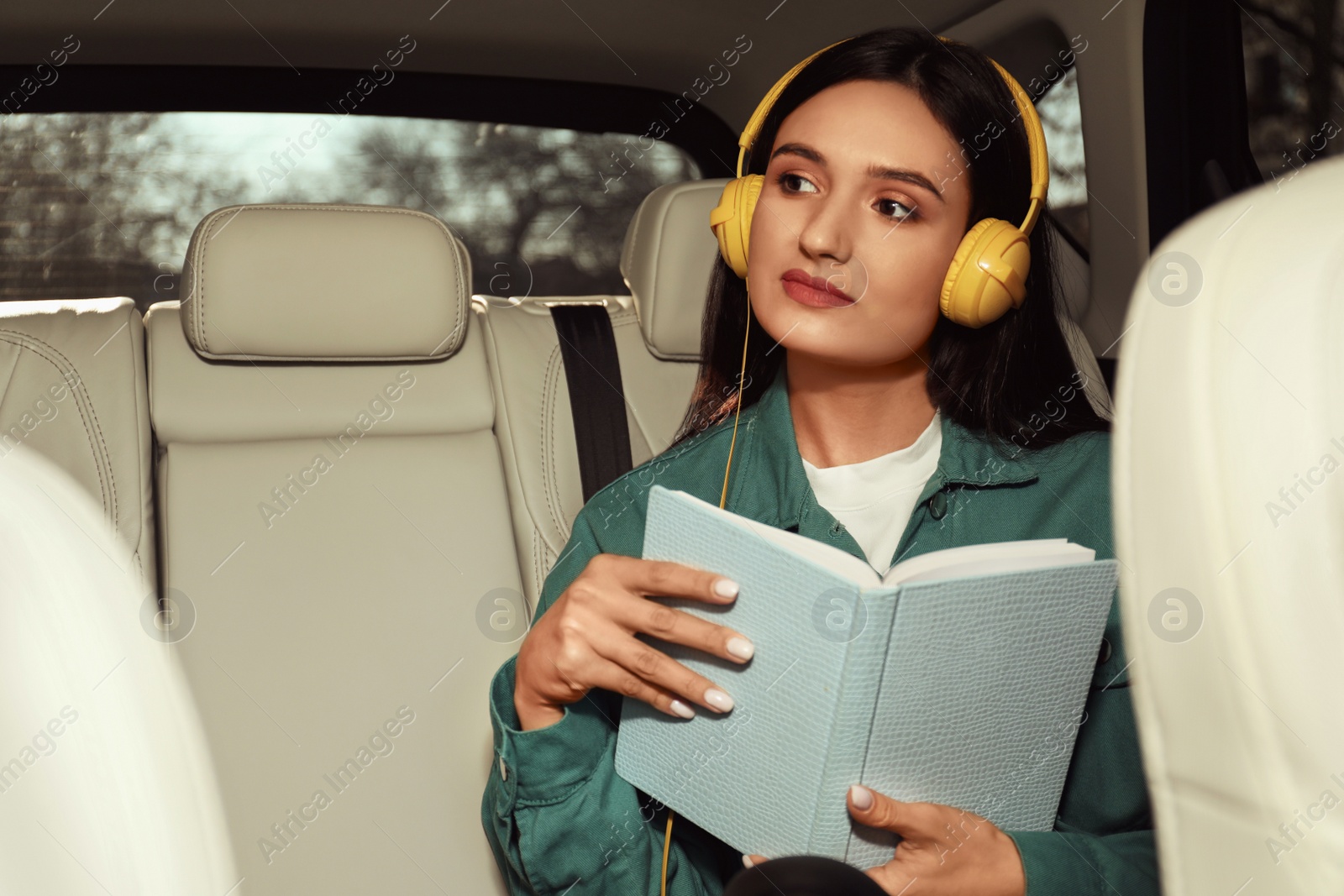 Photo of Young woman listening to audiobook in car