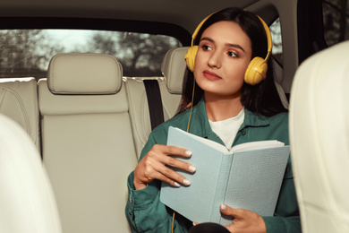 Young woman listening to audiobook in car