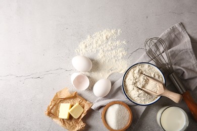Photo of Different ingredients for dough and whisk on light textured table, flat lay. Space for text