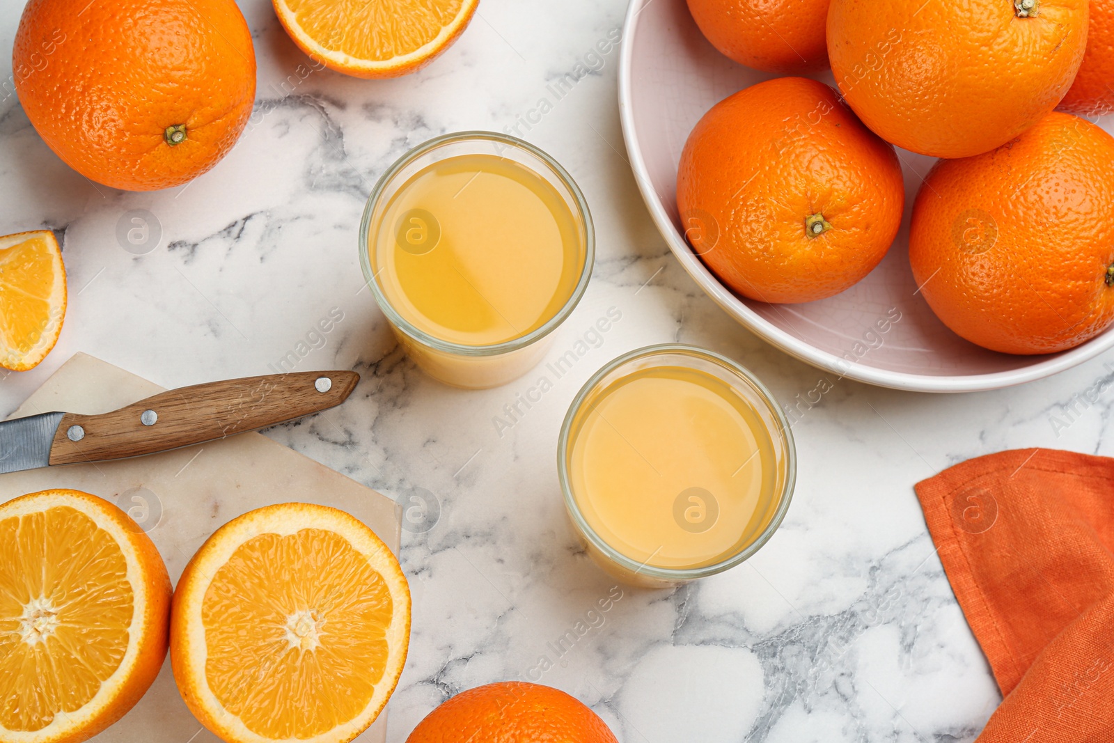 Photo of Delicious orange juice and fresh fruits on white marble table, flat lay