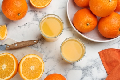 Delicious orange juice and fresh fruits on white marble table, flat lay