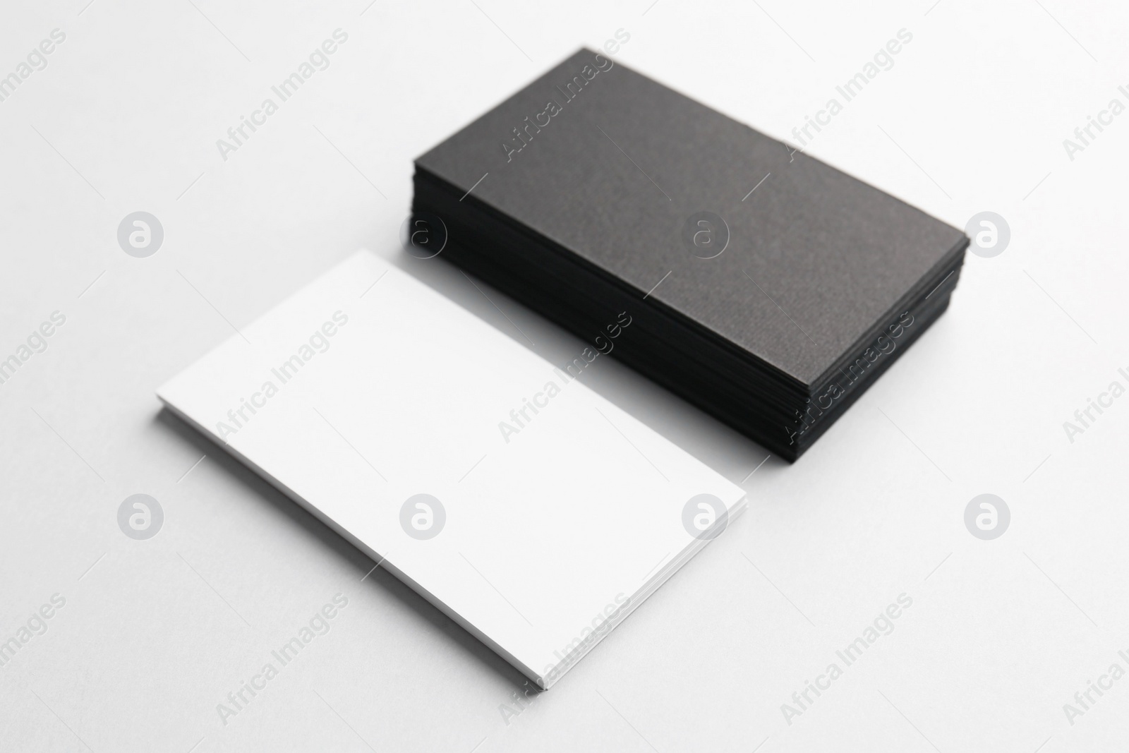 Photo of Blank black and white business cards on light background. Mockup for design