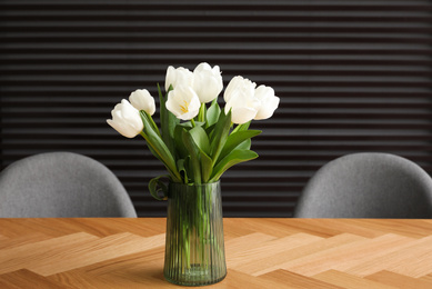 Photo of Beautiful bouquet of tulips on wooden table