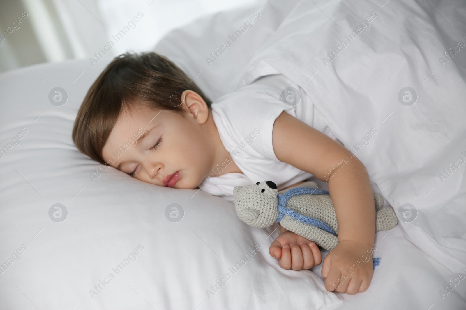 Photo of Cute little baby sleeping with toy at home. Bedtime