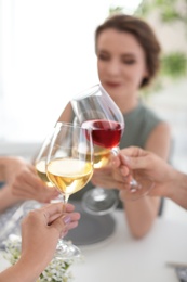 Photo of Young people with glasses of delicious wine at table