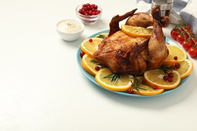 Photo of Baked chicken with orange slices on white table, space for text