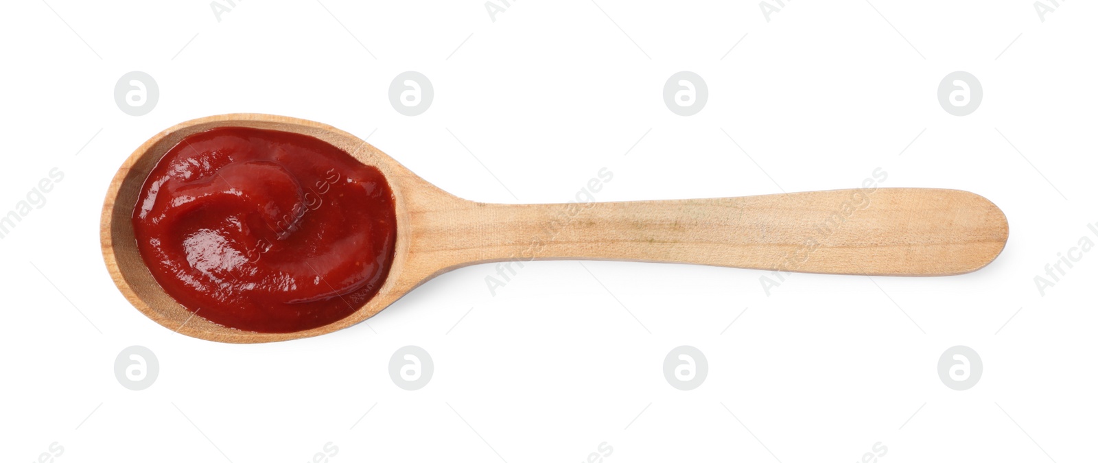 Photo of Ketchup in wooden spoon isolated on white, top view