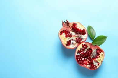 Photo of Ripe pomegranate halves on color background, top view with space for text