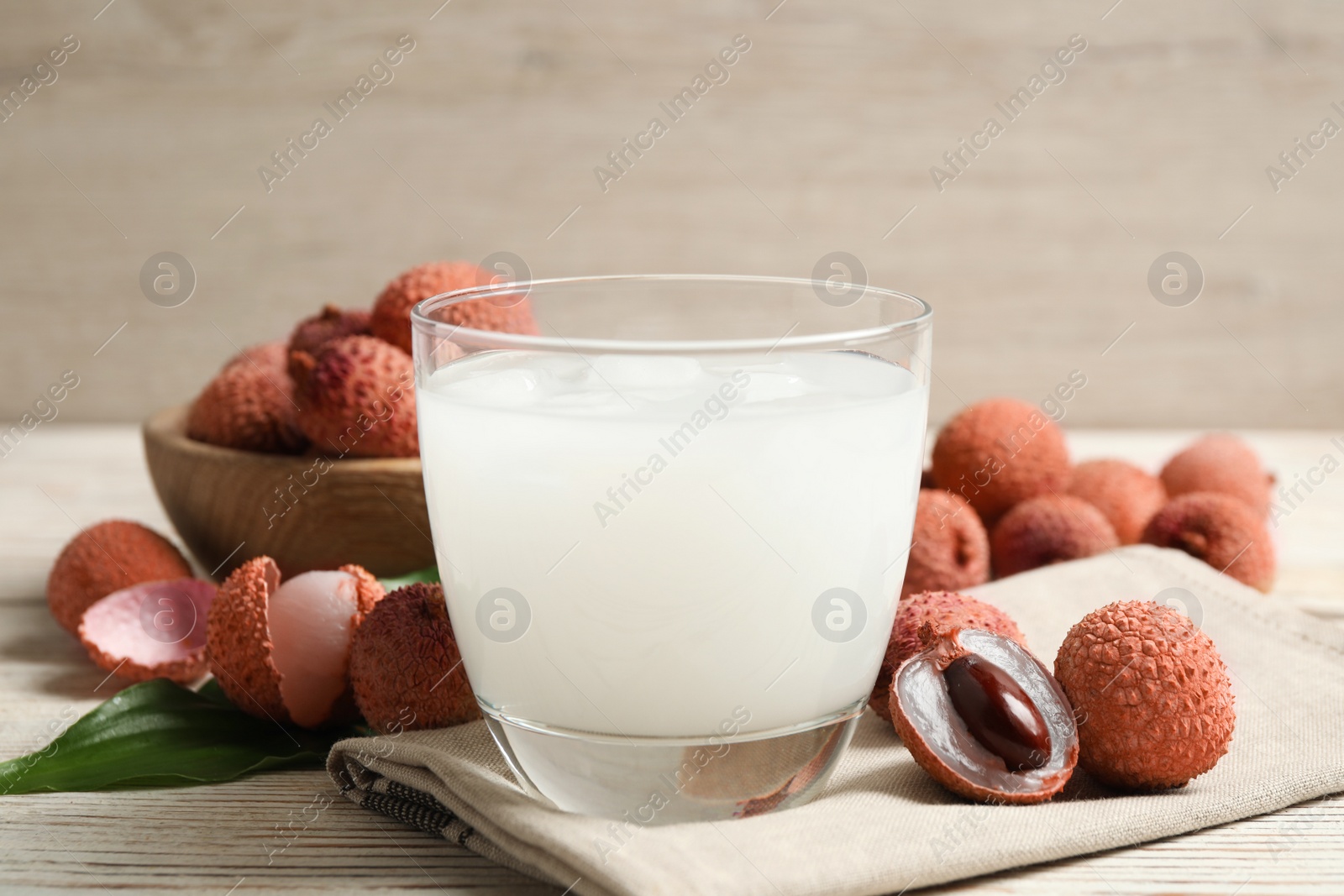 Photo of Fresh lychee juice and fruits on white wooden table