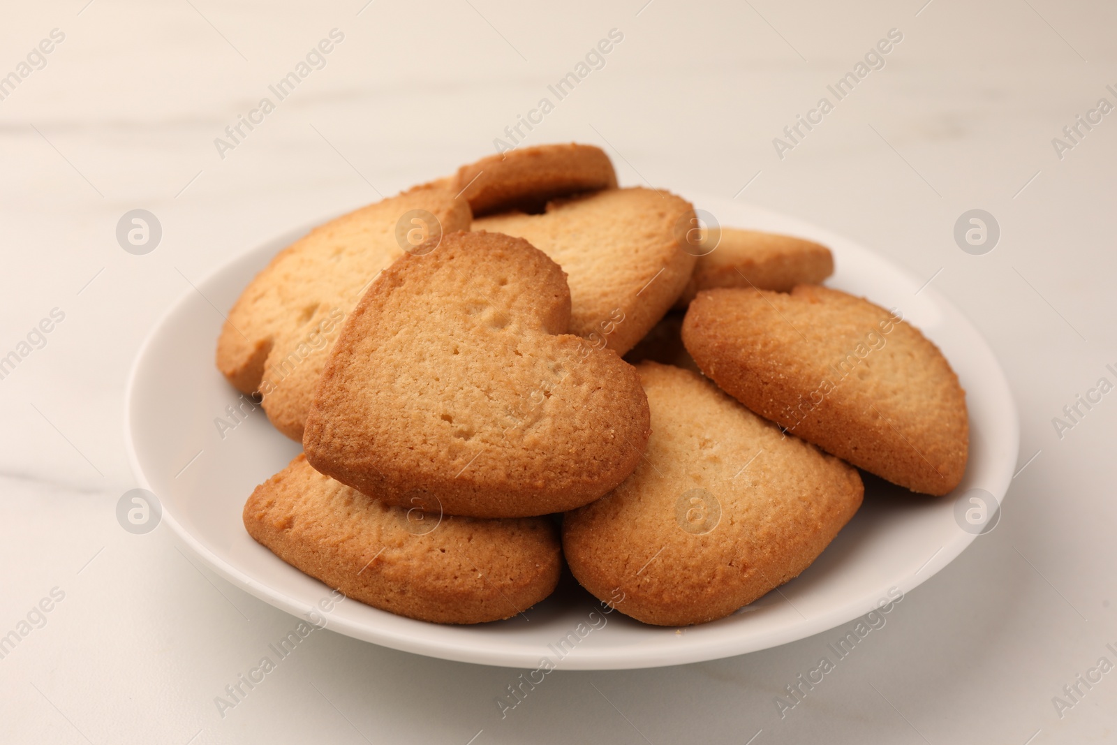 Photo of Heart shaped Danish butter cookies on white marble table, closeup