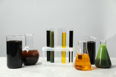 Photo of Laboratory glassware with different types of oil on white table