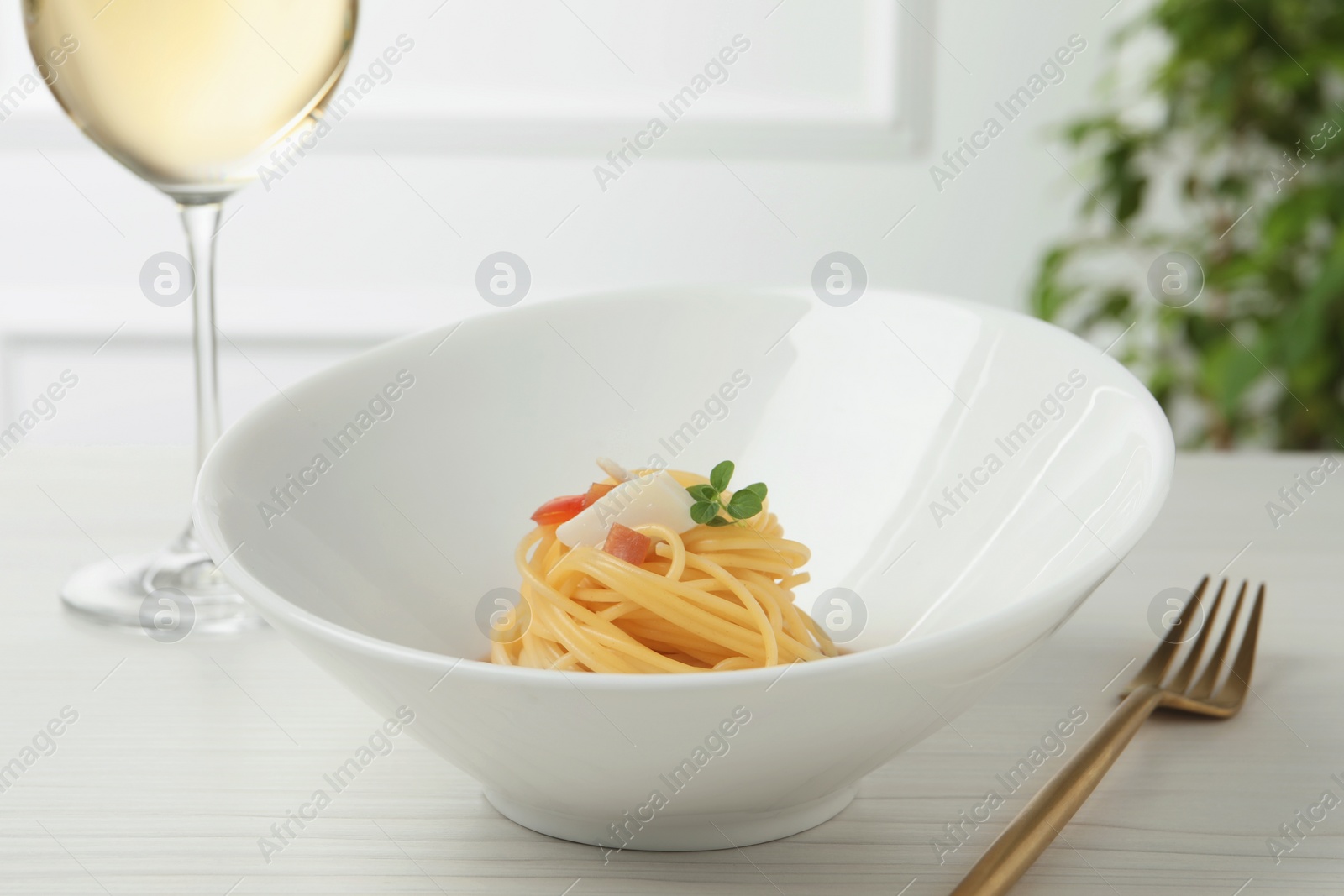 Photo of Tasty spaghetti with sauce served on white wooden table, closeup. Exquisite presentation of pasta dish