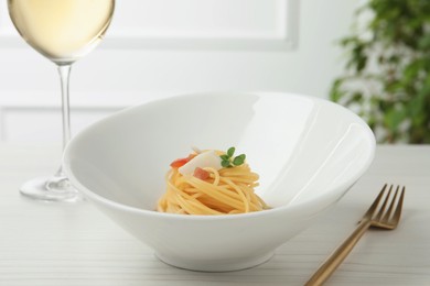 Photo of Tasty spaghetti with sauce served on white wooden table, closeup. Exquisite presentation of pasta dish