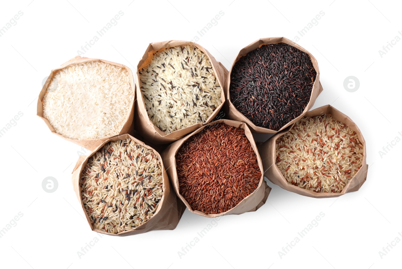 Photo of Brown and polished rice in paper bags on white background, top view