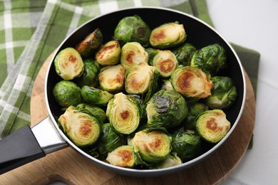Photo of Delicious roasted Brussels sprouts in frying pan on table, closeup