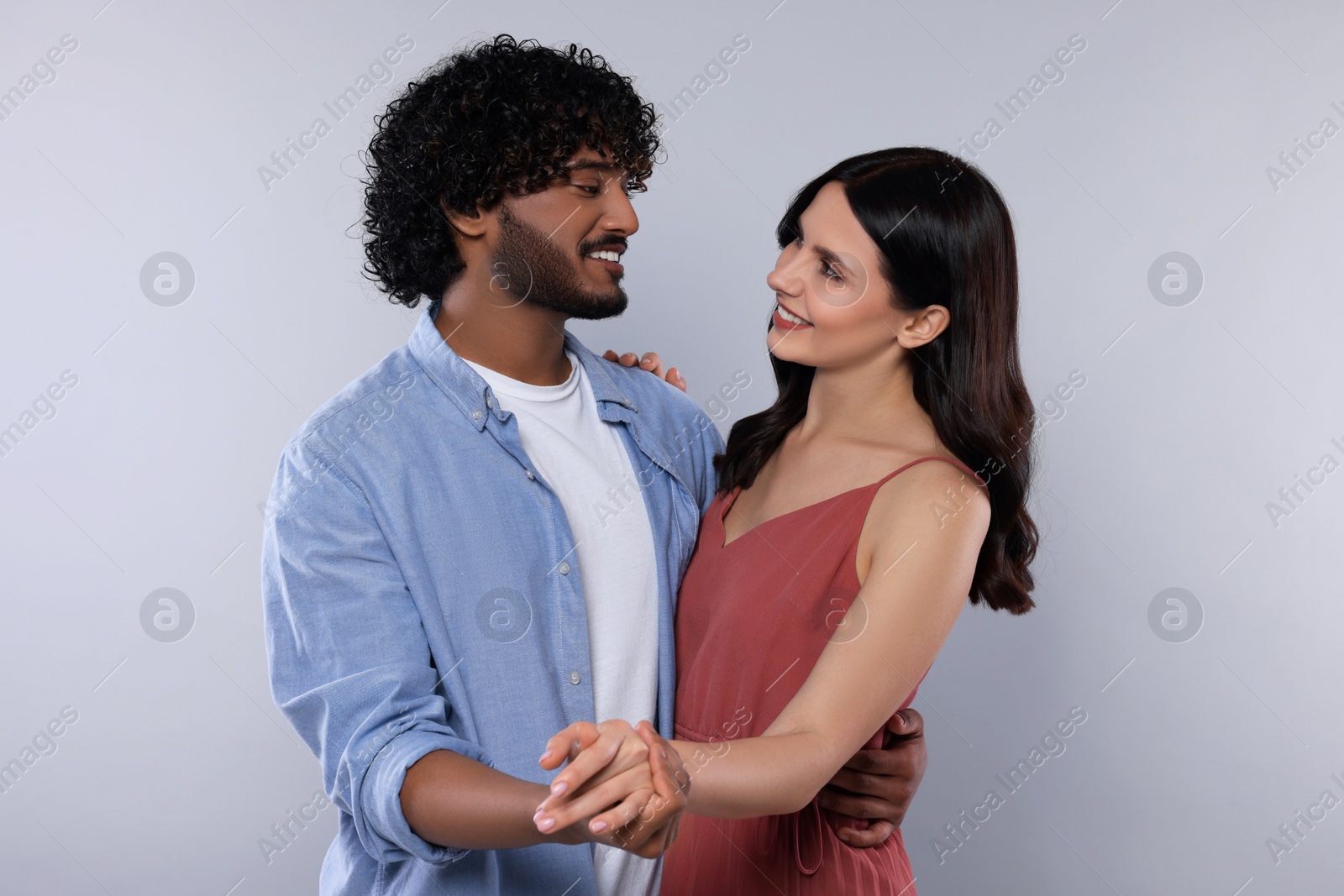 Photo of International dating. Happy couple dancing on light grey background