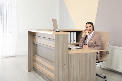 Photo of Portrait of receptionist working at desk in modern hotel