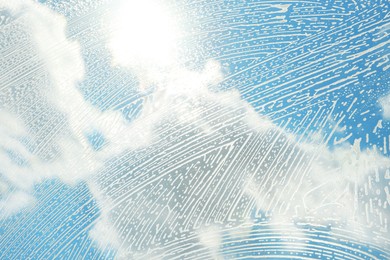 Photo of Cleaning foam on window glass, closeup view