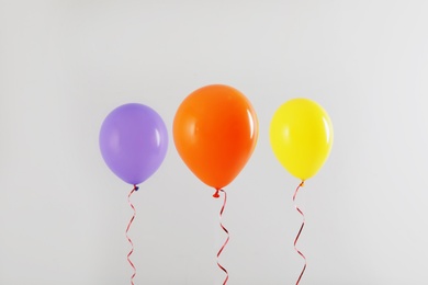 Different bright balloons on light background. Celebration time
