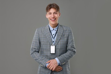 Photo of Happy man with blank badge on grey background