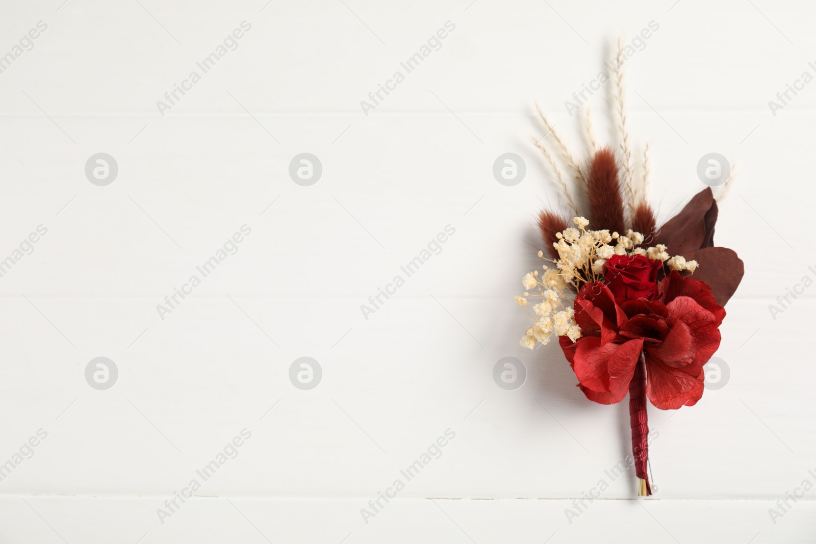 Photo of Beautiful boutonniere on white background, top view. Space for text