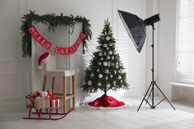 Beautiful photo zone with professional equipment and decorated Christmas tree