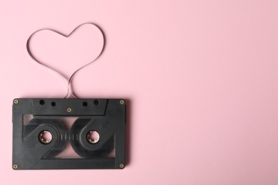 Photo of Top view of music cassette and heart made with tape on pink background, space for text. Listening love song