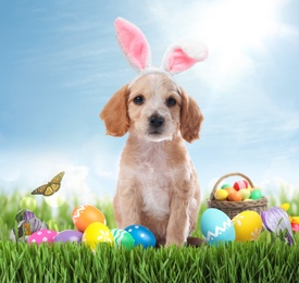 Image of Colorful Easter eggs and cute dog with bunny ears headband outdoors